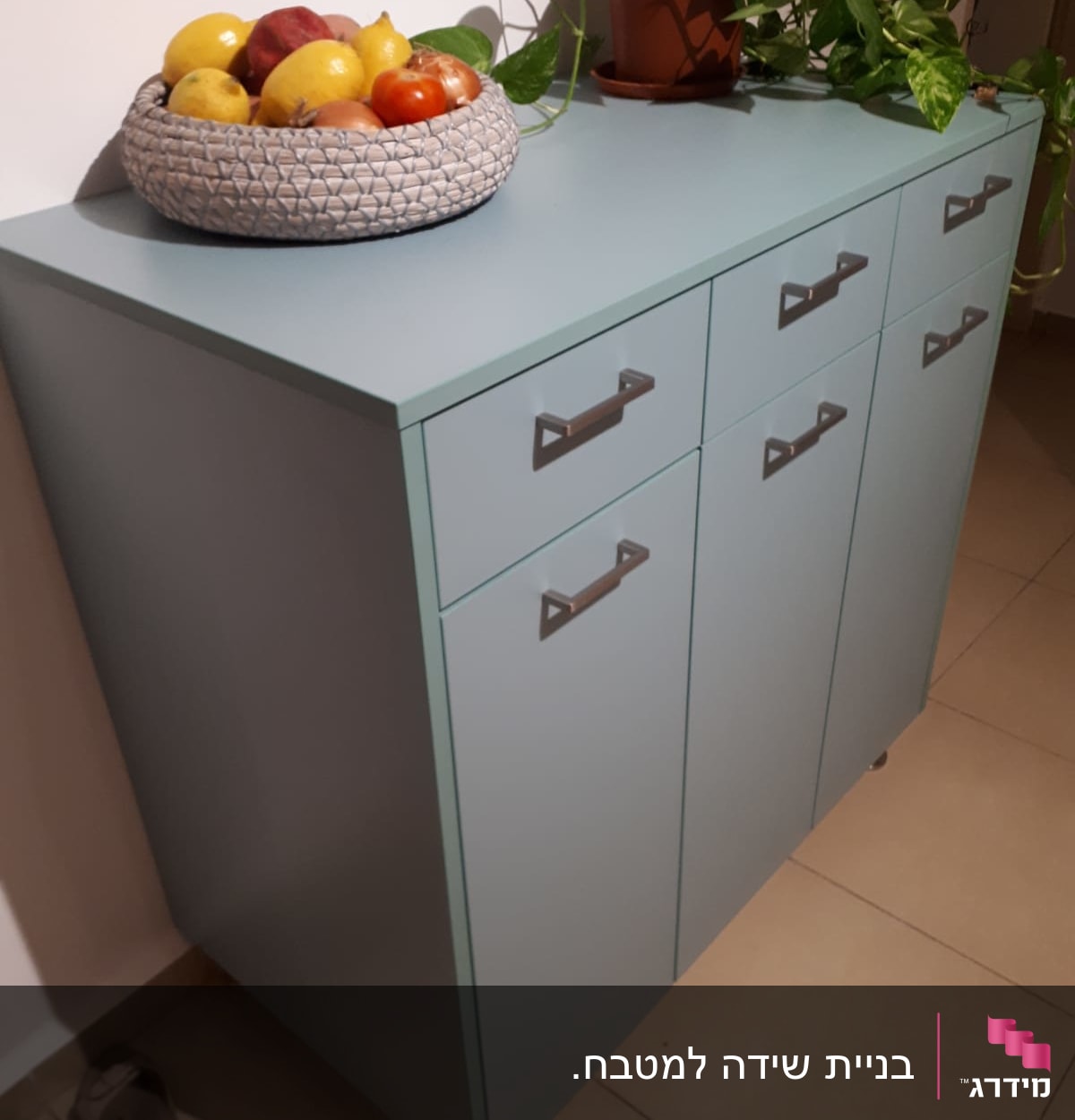 ארון מטבח עם סלסלת פירות וצמח ירוק